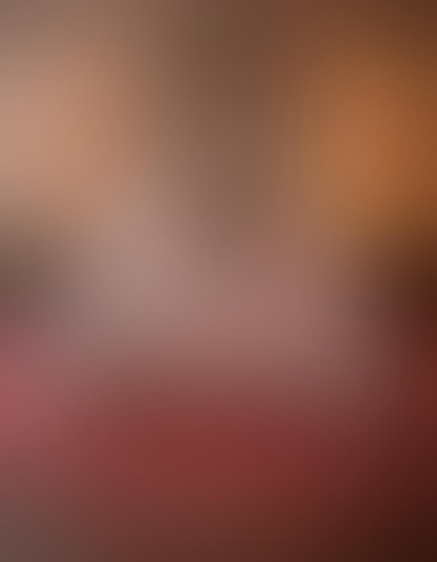 A romantic setting featuring a beautifully arranged bedroom with soft lighting, plush bedding, and intimate decor. In the foreground, an elegantly designed collection of sensual toys and couples' gear is artfully displayed, surrounded by rose petals and candlelight. A pair of softly intertwined hands in the background symbolizes connection and intimacy. The atmosphere exudes warmth and passion. super-realistic. warm tones. soft focus.